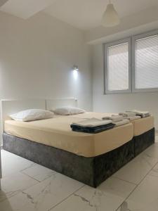 uma cama grande num quarto branco com um colchão grande em Skopje Boutique Apartments em Skopje