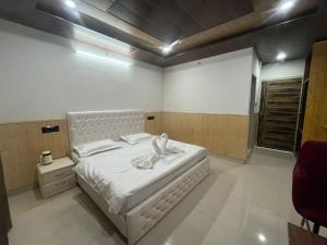 una camera da letto con un letto bianco con un arco sopra di Taarab View a Shogi