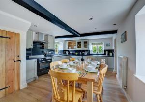 a kitchen with a wooden table and chairs at Top End Cottage 6 in Ringstead