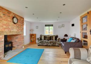 a living room with a couch and a fireplace at Top End Cottage 6 in Ringstead