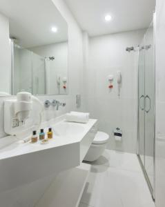 a white bathroom with a toilet and a shower at UK HOTEL İSTANBUL in Istanbul
