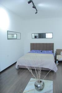 1 dormitorio con 1 cama y un jarrón en el suelo en Апартаменты Центр Медеуский Район, en Almaty