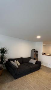 a living room with a black couch in a room at Albergue de Sonia in Finisterre