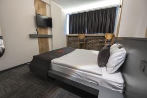 Una pequeña habitación con una cama y una ventana. en DEWY HOTEL, en Izmir