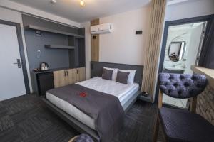 una habitación de hotel con una cama y una silla en DEWY HOTEL, en Izmir