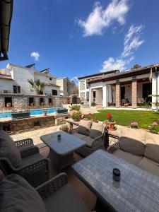 a patio with couches and tables and a pool at Akay Hotel in Selcuk