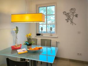 a dining room table with a bowl of oranges on it at Haus Meeresblick - Ferienwohnung Regenbogen A 1.19 (Ref. 132408 u 1) in Baabe