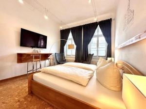 a bedroom with a bed and a desk and a television at Ferienwohnung an der Schelfkirche in Schwerin