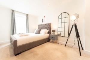 a bedroom with a bed and a floor lamp at Leeds City Centre 2 Bed 2 Bath in Leeds