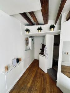 a living room with white walls and wooden floors at Appartement cosy en plein cœur de Paris in Paris