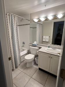 a white bathroom with a toilet and a sink at Harbour Retreat in Victoria