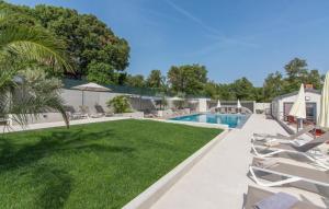 uma piscina com espreguiçadeiras e um quintal com piscina em Wohnung in Pješčana Uvala mit gemeinschaftlichem Pool und Grill em Pula