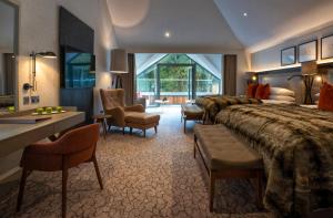 ein Hotelzimmer mit 4 Betten sowie einem Tisch und Stühlen in der Unterkunft Lodore Falls Hotel & Spa in Keswick