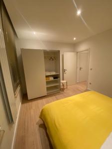 a bedroom with a yellow bed in a room at Cozy Flat in Brussels