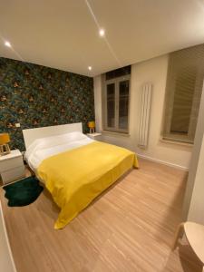 ein Schlafzimmer mit einem Bett mit einer gelben Decke in der Unterkunft Cozy Flat in Brüssel