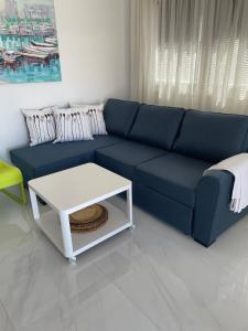 niebieską kanapę w salonie z białym stołem w obiekcie El Libre Playa Puerto Rico w mieście Puerto Rico de Gran Canaria