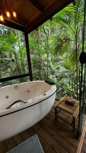 a bath tub sitting on a wooden deck with trees at Pousada Sitio Raizes in Siderópolis