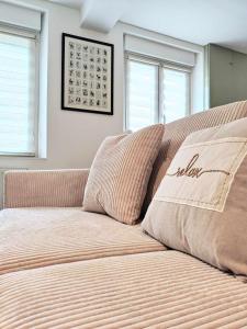 a couch in a room with two windows at La petite Flânerie in Mondrepuis