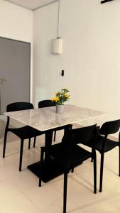 uma sala de jantar com uma mesa e cadeiras pretas em Prima falim em Ipoh