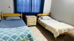 1 dormitorio con 2 camas, vestidor y ventana en Liliana, en Capiatá