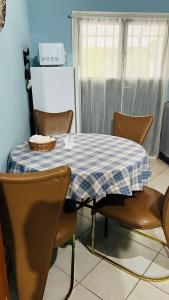 una mesa con un mantel y sillas de color azul y blanco a cuadros en Liliana, en Capiatá