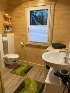 a bathroom with a sink and a toilet and a window at Emsflair in Kluse