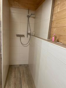 a shower in a bathroom with white tiles at Emsflair in Kluse