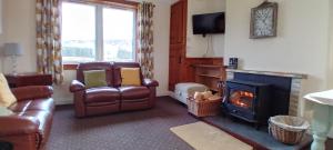 a living room with a couch and a fireplace at Mark cottage in Creetown