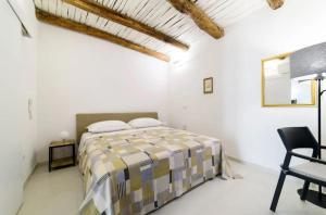- une chambre blanche avec un lit et une chaise dans l'établissement luxury and comfort in historic Salerno, à Salerne