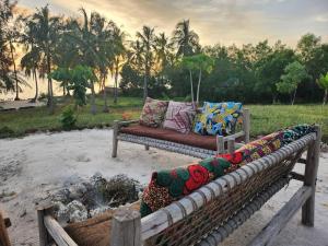 a couch with pillows on it sitting in a field at Sunset Getaway- Villa Makuti in Kizimkazi