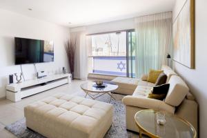 sala de estar con 2 sofás y TV en Marina Waterfront Haven by Sea N' Rent, en Herzelia 
