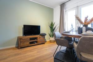 ein Wohnzimmer mit einem TV auf einem Holztisch in der Unterkunft Stilvolle 3-Zimmer Apartments I home2share in Lengerich