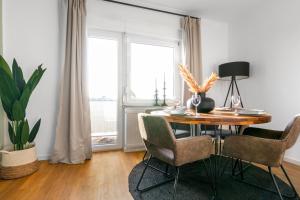 ein Esszimmer mit einem Tisch, Stühlen und einem Fenster in der Unterkunft Stilvolle 3-Zimmer Apartments I home2share in Lengerich