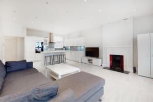 a living room with a couch and a fireplace at Modern 3 Bed Apartment in Hampstead in London