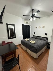 1 dormitorio con cama, mesa y ventilador de techo en Hotel Quito en Buenos Aires