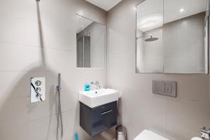 bagno bianco con lavandino e specchio di Modern 3 Bed Apartment in Hampstead a Londra