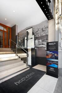 a lobby with stairs and a mural of a city at HCC Regente in Barcelona