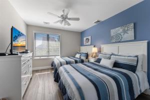 a bedroom with two beds and a ceiling fan at 116 Austin Ave in Wildwood