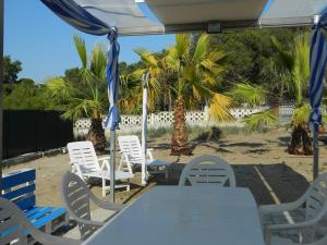 una mesa y sillas bajo una sombrilla en la playa en Villa Robinia, en Massafra
