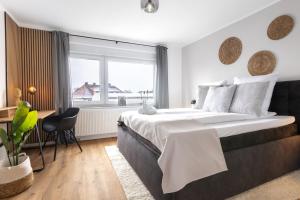 a bedroom with a large bed with a desk and a window at Stilvolle 3-Zimmer Apartments I home2share in Lengerich