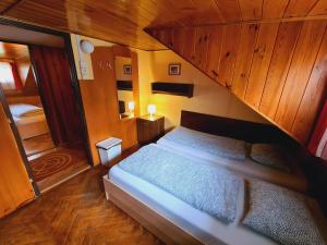 a bedroom with a bed with a wooden ceiling at Penzion Poslední míle in Milovy