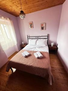 sypialnia z łóżkiem z dwoma ręcznikami w obiekcie Tolis House w Korfu