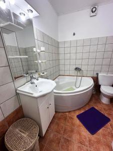 uma casa de banho com uma banheira, um lavatório e um WC. em Tolis House em Corfu Town