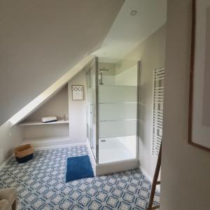 a bathroom with a walk in shower in the attic at Gîte La Frévalette in Thiétreville