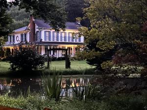 a large house with a pond in front of it at Historic Seaton Springs Farm B&B - James Tipton En-Suite Triple Room in Sevierville