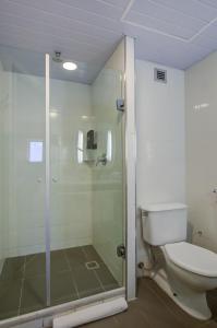 uma casa de banho com um WC e uma cabina de duche em vidro. em Rio hotel by Bourbon Indaiatuba Viracopos em Indaiatuba