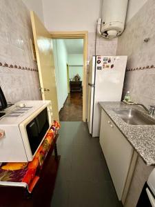 a kitchen with a microwave and a sink and a refrigerator at DPTO 3 AMB in Mar del Plata