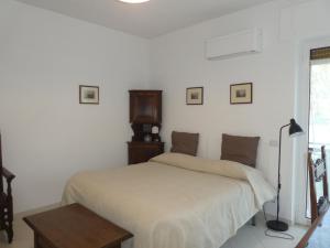 a white bedroom with a bed and a table at SoggiorniSorrento in Sorrento