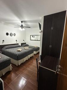 um quarto com 3 camas, uma mesa e um tecto em Hotel Quito em Buenos Aires