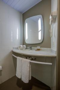 a bathroom with a sink with a mirror and towels at Rio hotel by Bourbon Indaiatuba Viracopos in Indaiatuba